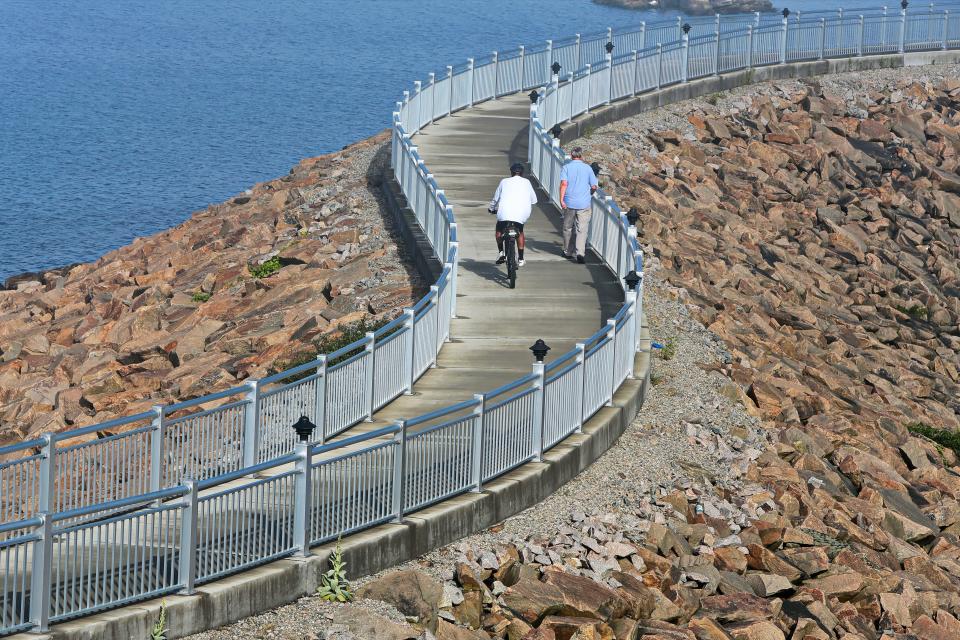 A cyclist and walker share the hurricane barrier walk in the south end of New Bedford.