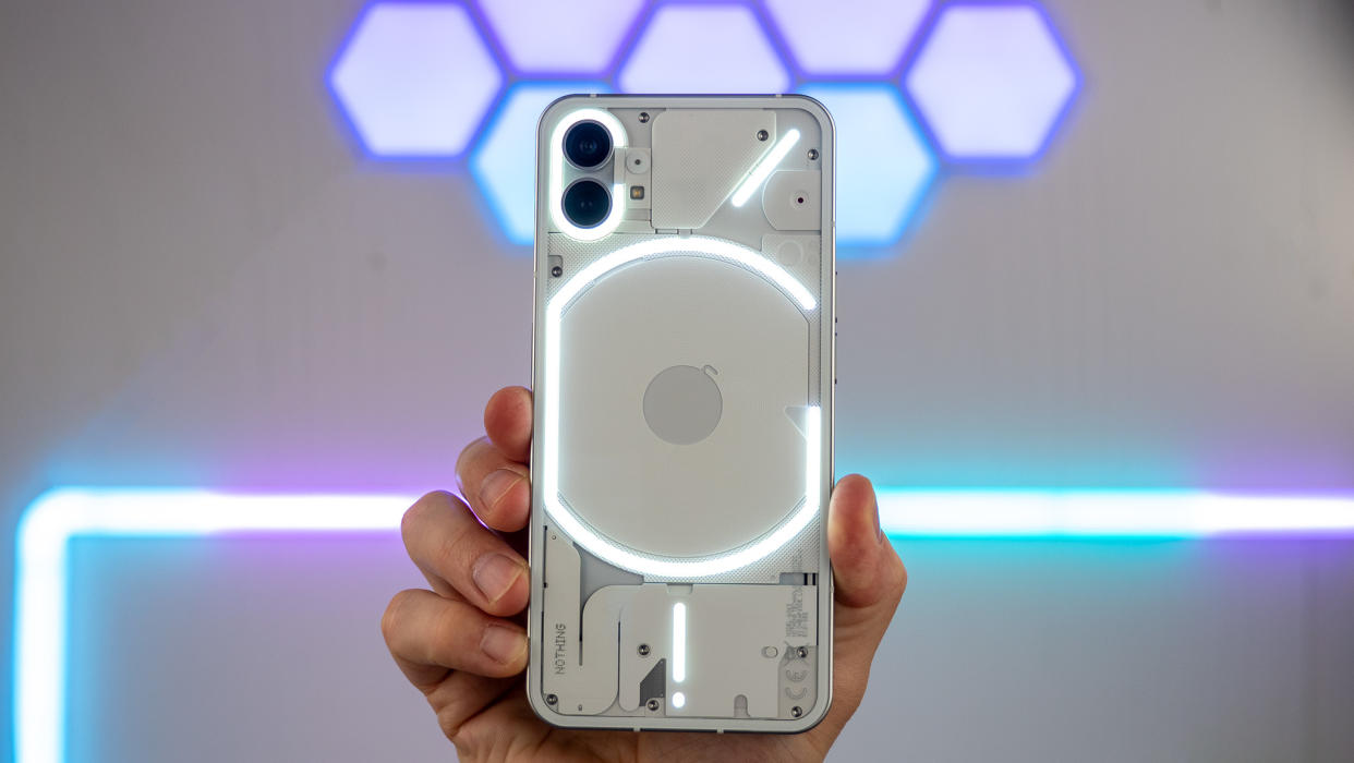  Holding up the Nothing phone (1) with its glyph lights illuminated in front of Govee Hex and Glide lights in the background 