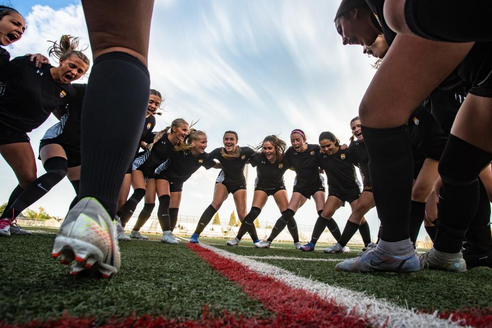Rocky Mountain girls soccer players gather in a huddle before a high school playoff game against Cherokee Trail on Tuesday. The Lobos followed a first-round win with a second-round overtime upset win to make the quarterfinals.