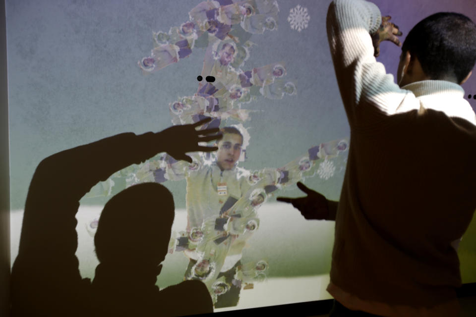 Bronx Preparatory Charter School student Pablo Flores experiments with an exhibit called the "Human Tree" at the new National Museum of Mathematics in New York, Monday, Dec. 17, 2012. The museum is aimed at kids aged 8 to 13, and curators have given the place a playground feel. The 40 exhibits include a "wall of fire" made up of laser lights that teaches kids about geometry and a square-wheeled tricycle that still manages to produce a smooth ride thanks to a wavy track. (AP Photo/Seth Wenig)