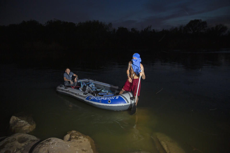 Smugglers talk to journalists after they delivered a group of migrants across the Rio Grande river in Roma, Texas, Wednesday, March 24, 2021. A surge of migrants on the Southwest border has the Biden administration on the defensive. The head of Homeland Security acknowledged the severity of the problem but insisted it's under control and said he won't revive a Trump-era practice of immediately expelling teens and children. (AP Photo/Dario Lopez-Mills)