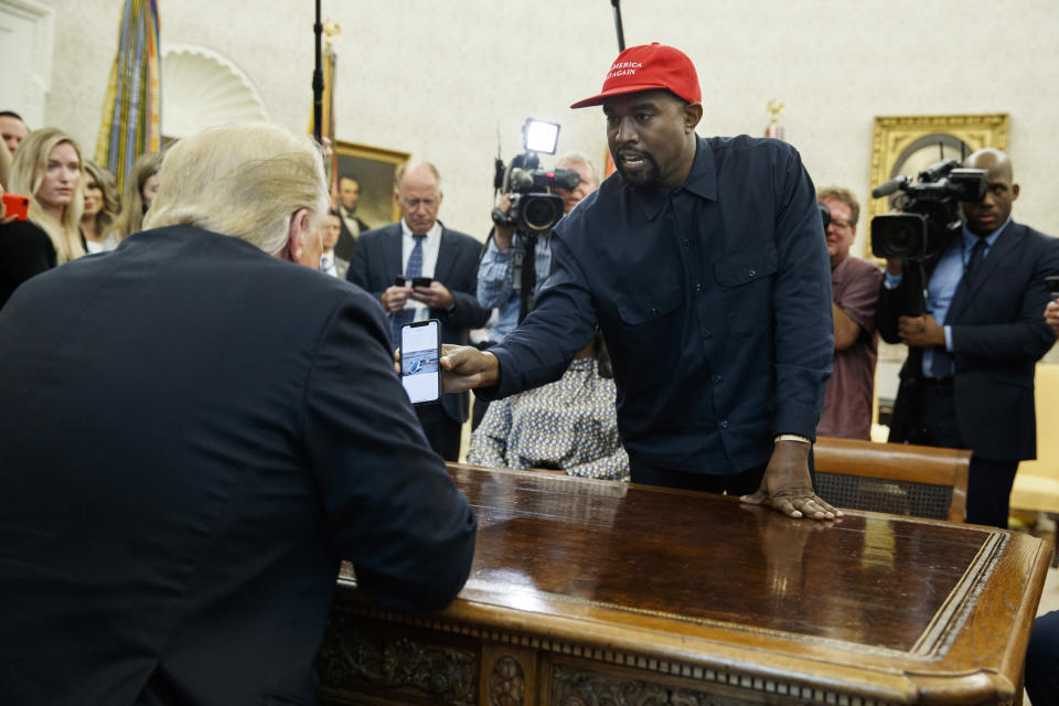 Rapper Kanye West shows President Donald Trump a photograph of a hydrogen plane during a meeting in the Oval Office of the White House, Thursday, Oct. 11, 2018, in Washington. (AP Photo/Evan Vucci)