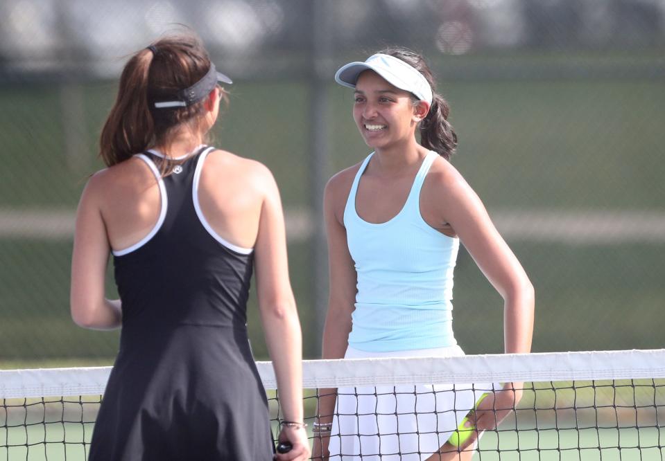 Ashi Amalnathan, right, No. 1 singles player for Saint Joseph High School, greets Penn No. 1 player Aileen Hu Thursday, April 20, 2023, in an NIC girls tennis match at Leeper Park Tennis courts in South Bend.