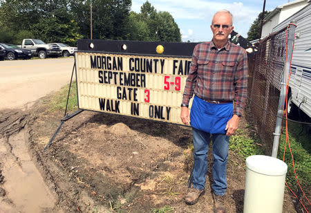 John Wilson, 70, stands next to a sign at the Morgan County Fair in McConnelsville, Ohio, U.S., September 6, 2017. Photo taken September 6, 2017. REUTERS/Tim Reid