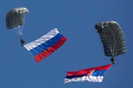 Serbian paratroopers descend to the ground holding Serbian and Russian (L) national flags during a training exercise in the village of Nikinci, west from Belgrade, Serbia, November 14, 2014. REUTERS/Marko Djurica/File Photo