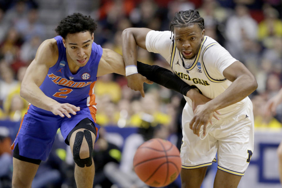 <p>Florida’s Andrew Nembhard (2) and Michigan’s Zavier Simpson (3) go for a loose ball during the first half of a second round men’s college basketball game in the NCAA Tournament, in Des Moines, Iowa, Saturday, March 23, 2019. (AP Photo/Nati Harnik) </p>