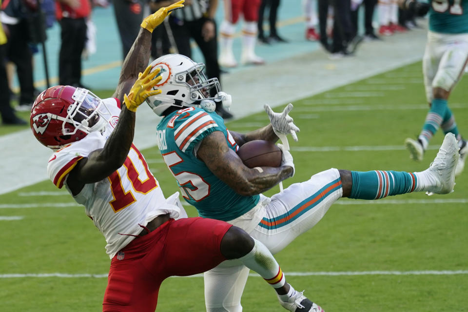 FILE - Miami Dolphins cornerback Xavien Howard (25) intercepts a pass intended for Kansas City Chiefs wide receiver Tyreek Hill (10), during the second half of an NFL football game in Miami Gardens, Fla., in this Sunday, Dec. 13, 2020, file photo. All-Pro cornerback Xavien Howard joined the rest of the Miami Dolphins reporting for training camp Tuesday, July 27, 2021, after he sat out mandatory minicamp because he's unhappy about his contract. (AP Photo/Lynne Sladky, File)