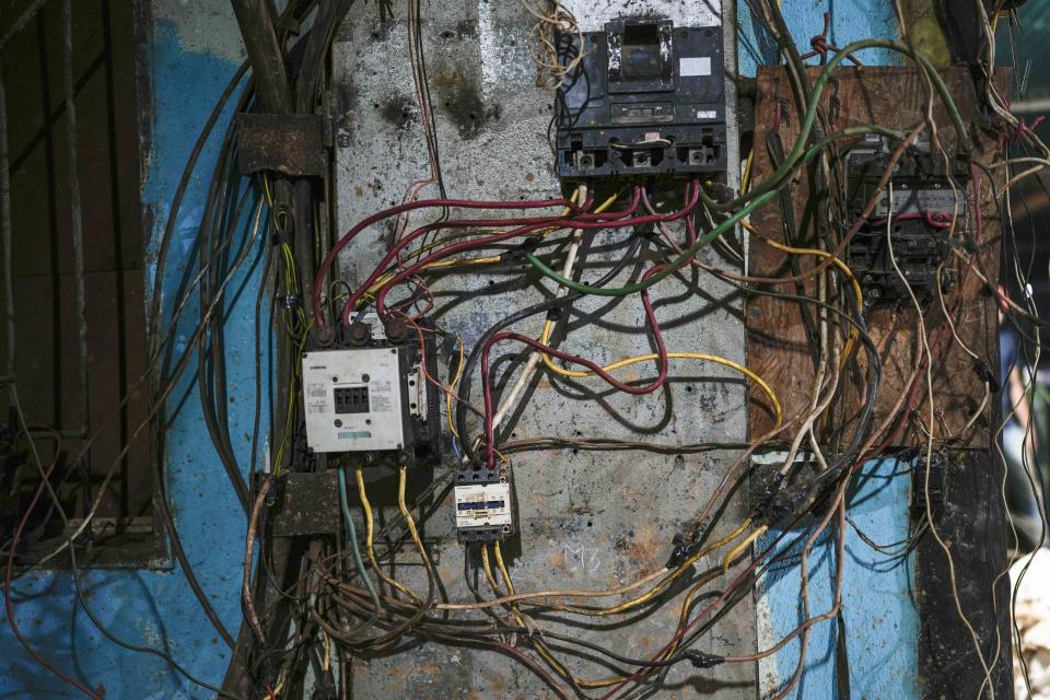 Una maraña de cables forma parte del sistema de electricidad para hacer que funcionen bombas de agua y proveer iluminación parcial en una mina subterránea de oro en El Callao, estado Bolívar, en Venezuela, el viernes 28 de abril de 2023. (AP Foto/Matias Delacroix)