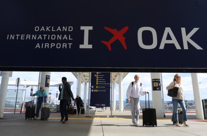 OAKLAND, CALIFORNIA - APRIL 12: Travelers walk towards Terminal 2 at Oakland International Airport on April 12, 2024 in Oakland, California. The Board of Commissioners for the Port of Oakland voted on Thursday to proceed with a plan to change the name of Oakland International Airport to the San Francisco Bay Oakland International Airport. San Francisco officials are objecting to the proposed name change and have threatened to file a lawsuit arguing it would violate the city's trademark on San Francisco International Airport and would potentially be confusing for people traveling to the area. (Photo by Justin Sullivan/Getty Images)