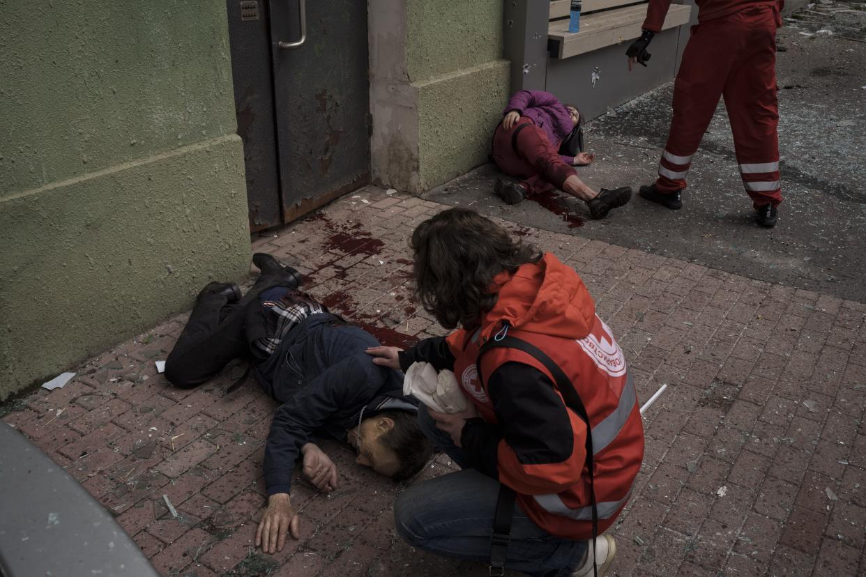 Emergency workers help injured civilians during a Russian bombardment in Kharkiv, Ukraine, Sunday, April 17, 2022. 