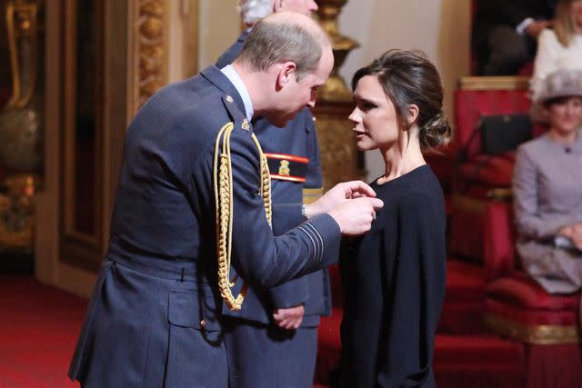 <p>PA Images/Sipa</p> Victoria Beckham receives her OBE from Prince William