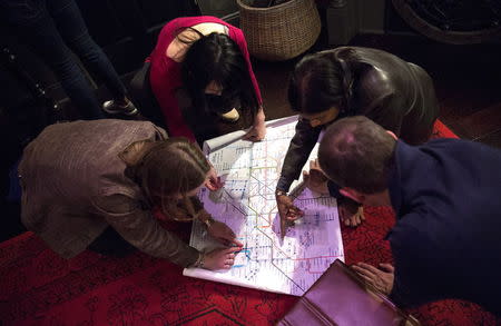 People work to find clues and solve puzzles to escape from a Sherlock Holmes-themed escape room in Alexandria, Virginia, October 17, 2015. REUTERS/Joshua Roberts