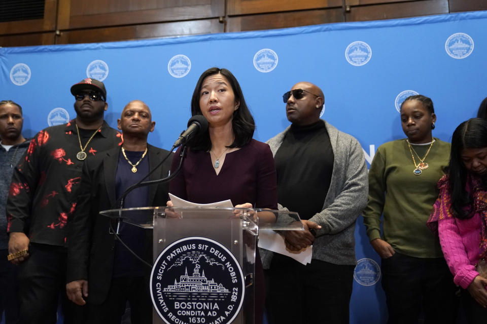 Boston Mayor Michelle Wu, center, issues a formal apology to Alan Swanson and Willie Bennett, Wednesday, Dec. 20, 2023, during a news conference, in Boston, for their wrongful arrests following the 1989 death of Carol Stuart, whose husband, Charles Stuart, had orchestrated her murder. (AP Photo/Steven Senne)