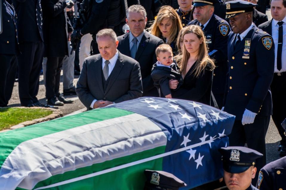 Diller’s widow and their son watch over the slain NYPD detective’s casket. REUTERS