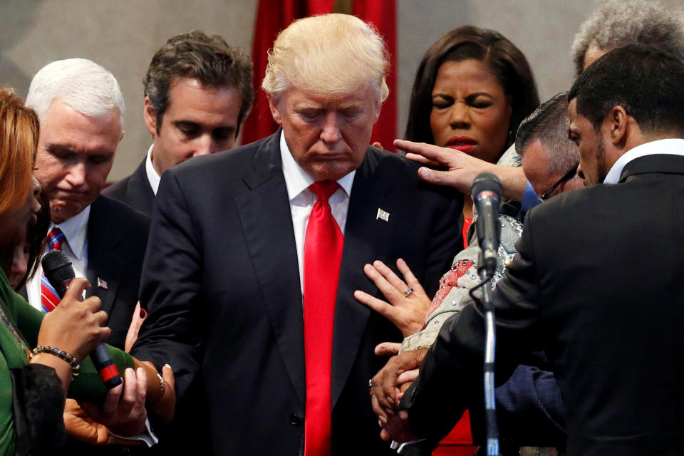 Members of the clergy lay hands and pray over Republican presidential nominee Donald Trump at the New Spirit Revival Center in Cleveland Heights, Ohio, U.S., September 21, 2016. REUTERS/Jonathan Ernst TPX IMAGES OF THE DAY