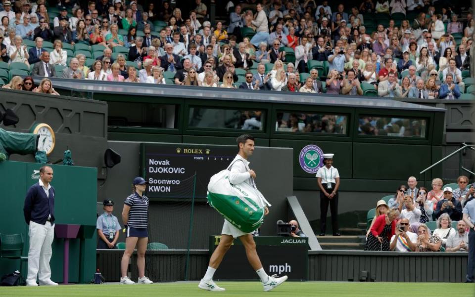 The Centre Court crowd applaud Novak Djokovic as he steps out on court for his first round match against Soonwoo Kwon.