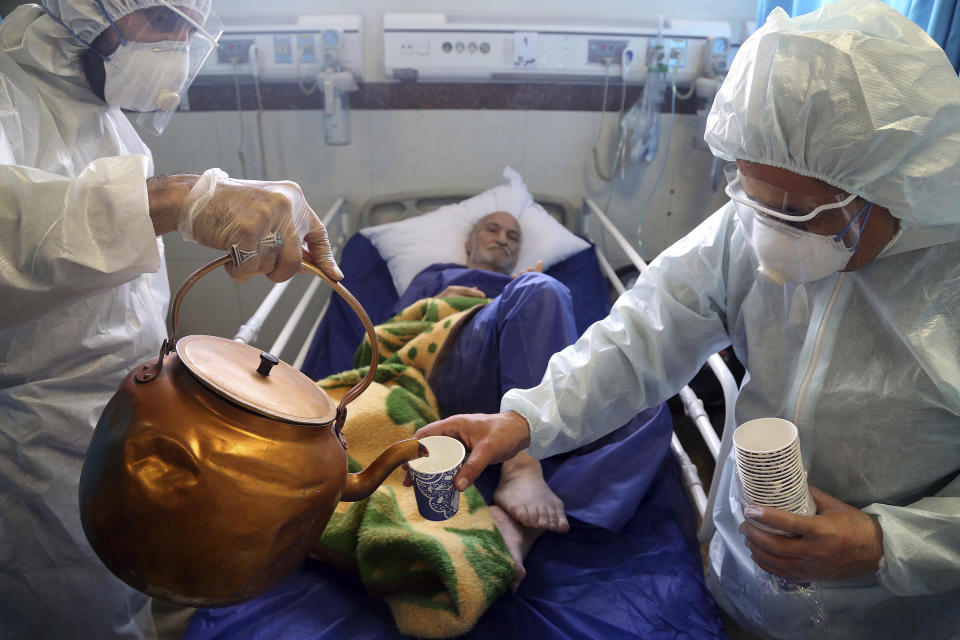 Medical workers pour tea for a patient infected with the new coronavirus at a hospital in Tehran, Iran, March 8, 2020. (AP Photo/Mohammad Ghadamali)