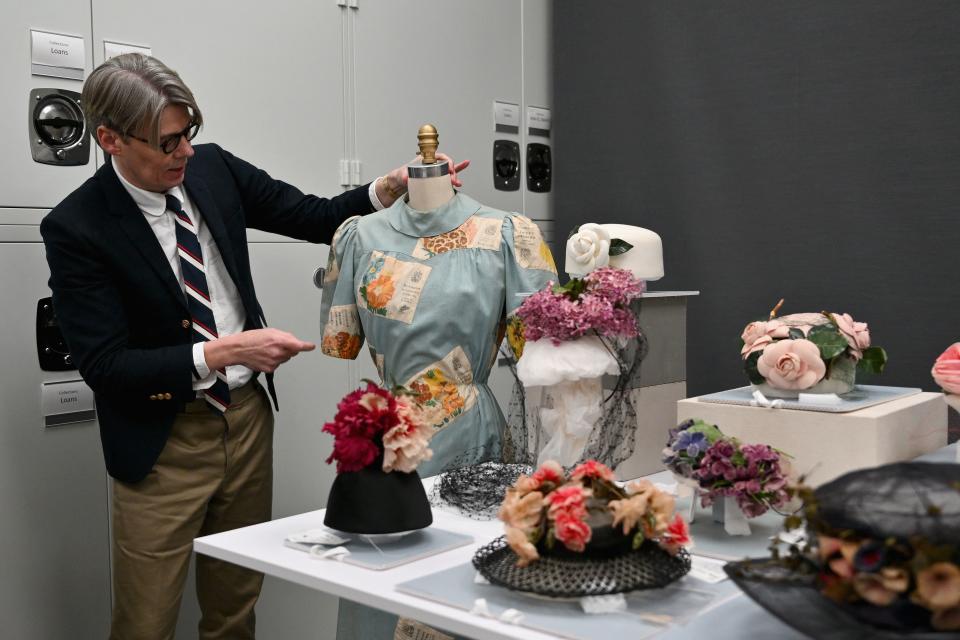 Man showcasing vintage fashion accessories inside an archival room