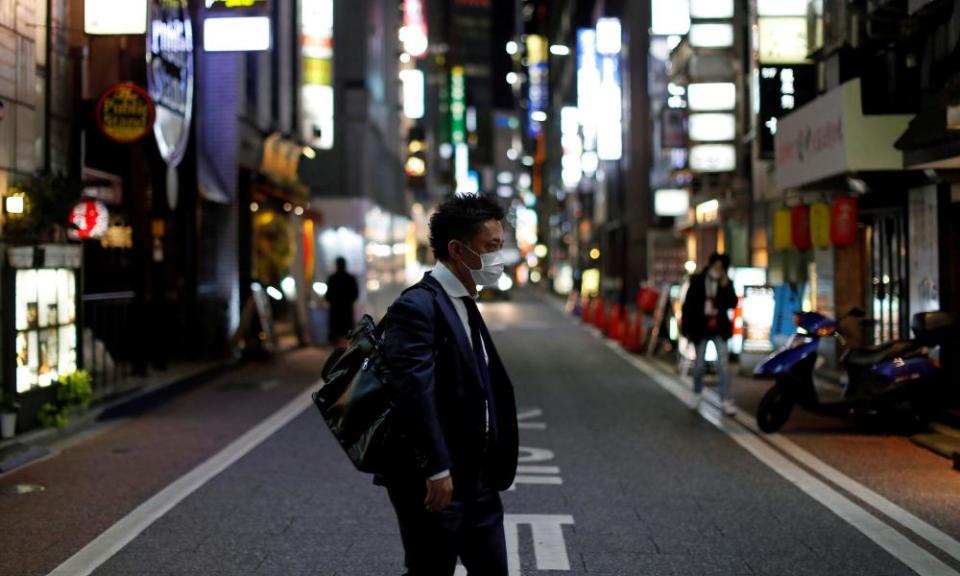 A man wearing a protective face mask, following an outbreak of the coronavirus disease, walks at Ginza shopping and amusement district in Tokyo