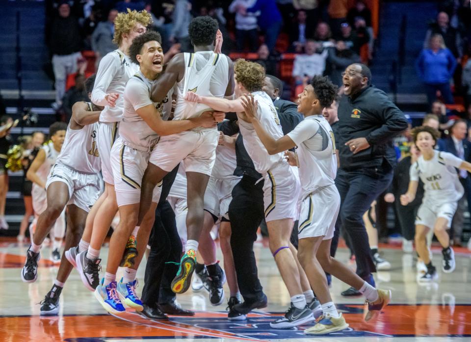 The Springfield Sacred Heart-Griffin Cyclones celebrate their 53-50 double overtime victory over the Metamora Redbirds in the Class 3A state basketball title game Saturday, March 12, 2022 at the State Farm Center in Champaign.