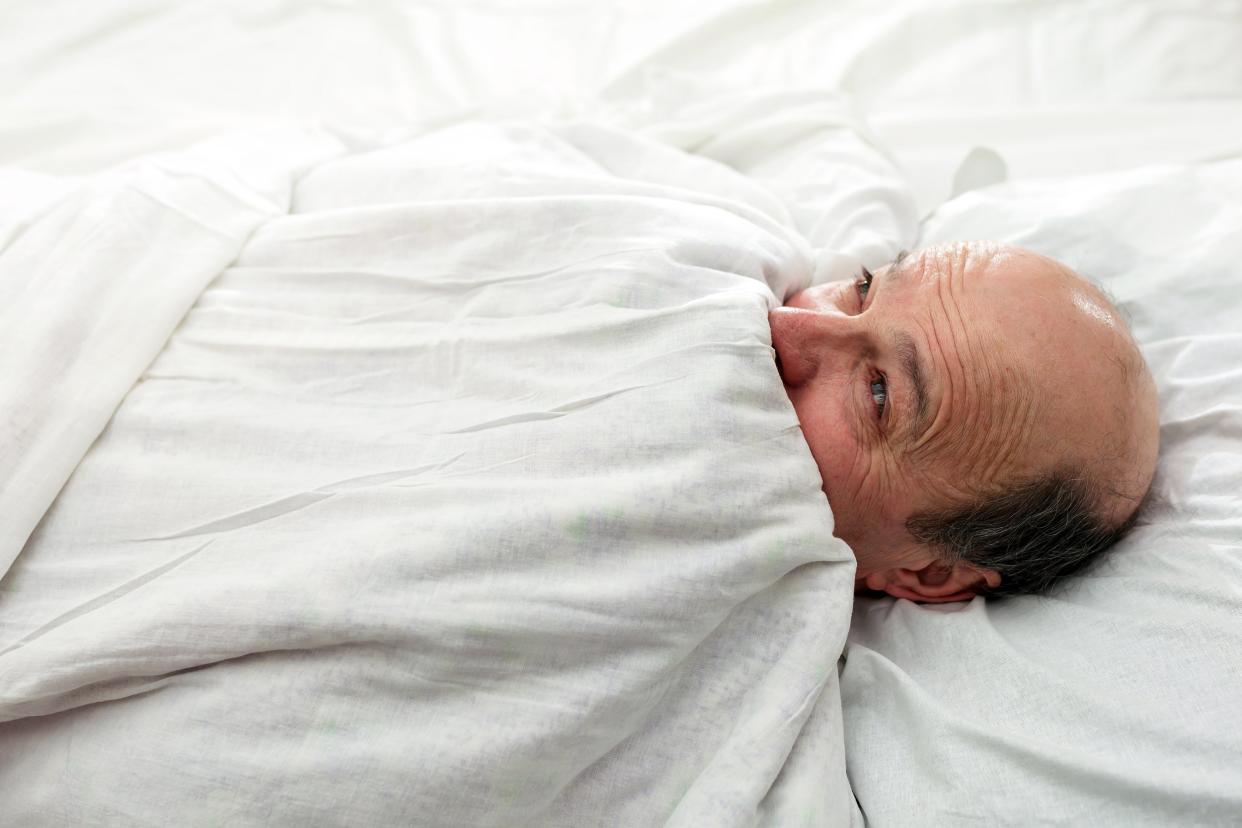 Man cold at night with blankets up to his face