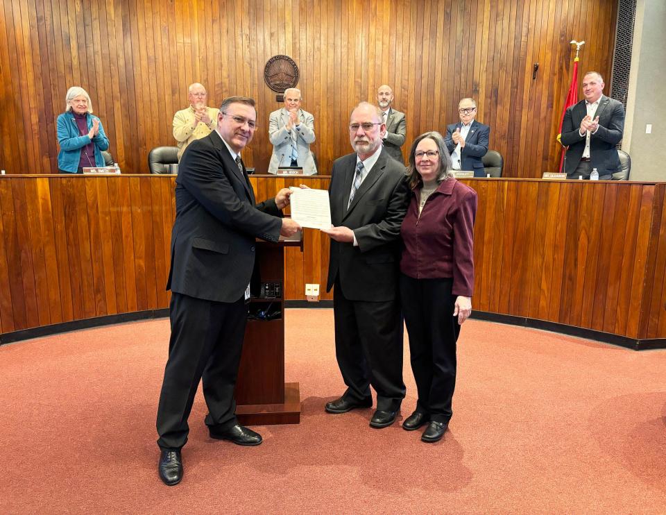 Oak Ridge City Council applauds at its March meeting as City Manager Randy Hemann presents Jack Suggs, with his wife Joan, a proclamation upon his retirement after 40 years of public service.