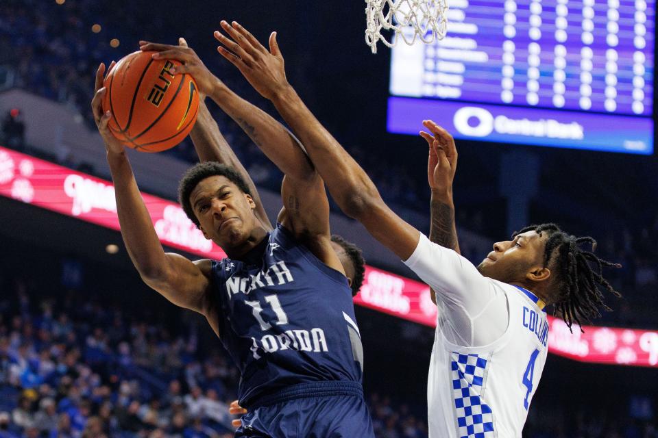 UNF forward Jonathan Aybar (21) battles Kentucky's Daimion Collins for a rebound last year in Lexington, Ky. UNF's game against Houston on Tuesday will mark its eighth game against 2021-22 NCAA tournament teams in the last two years.