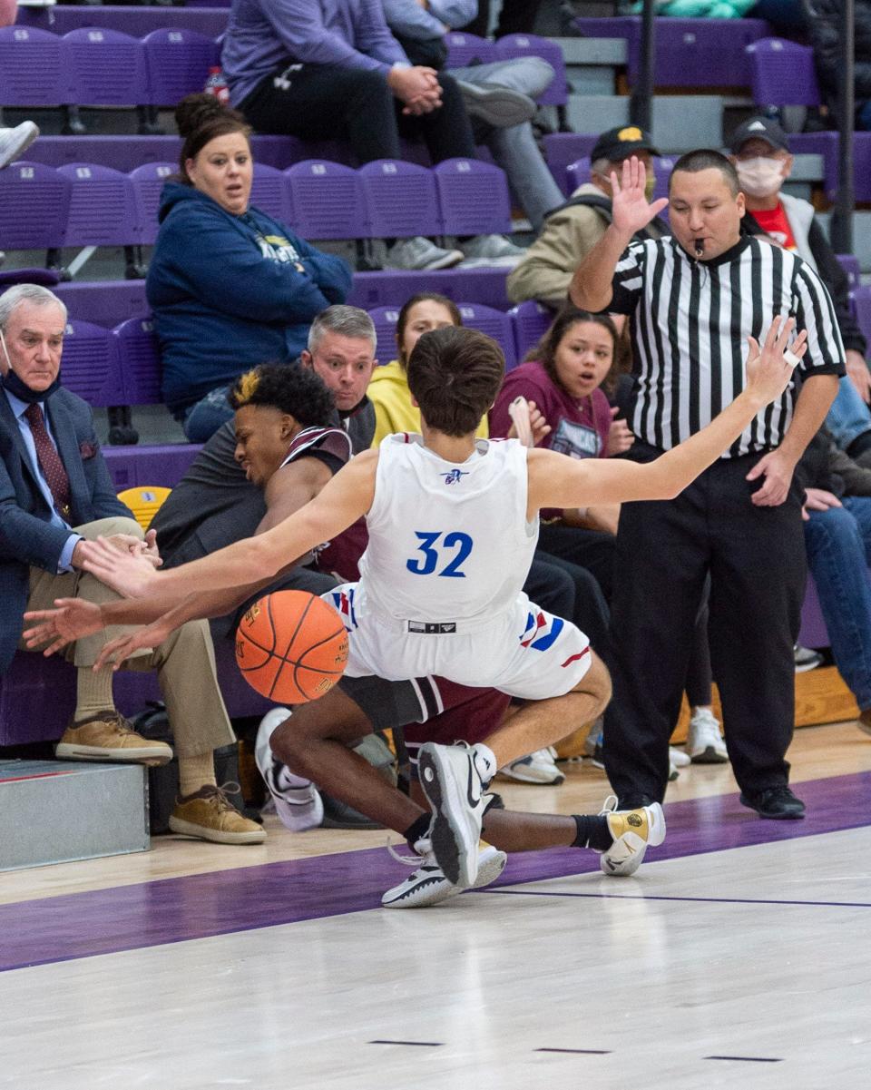 Andover's Brad Harris (32) draws a controversial charge against Salina Central's Sid Duplessis near the end of the Trojans' 62-58 semifinal victory during Friday's semifinals of the Salina Invitational Tournament at Mabee Arena.