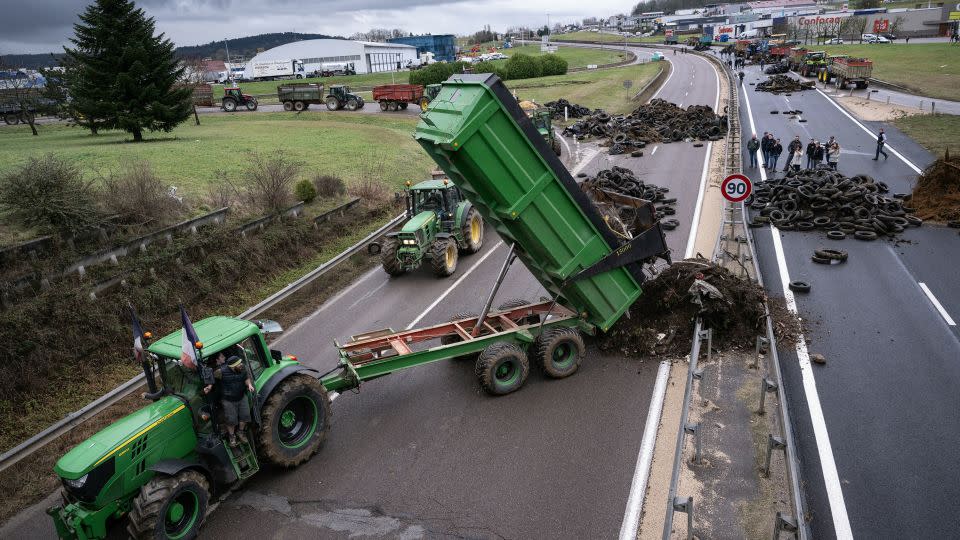A farmer pulls waste to block a highway near Vesoul, eastern France. - Sebastien Bozon/AFP via Getty Images