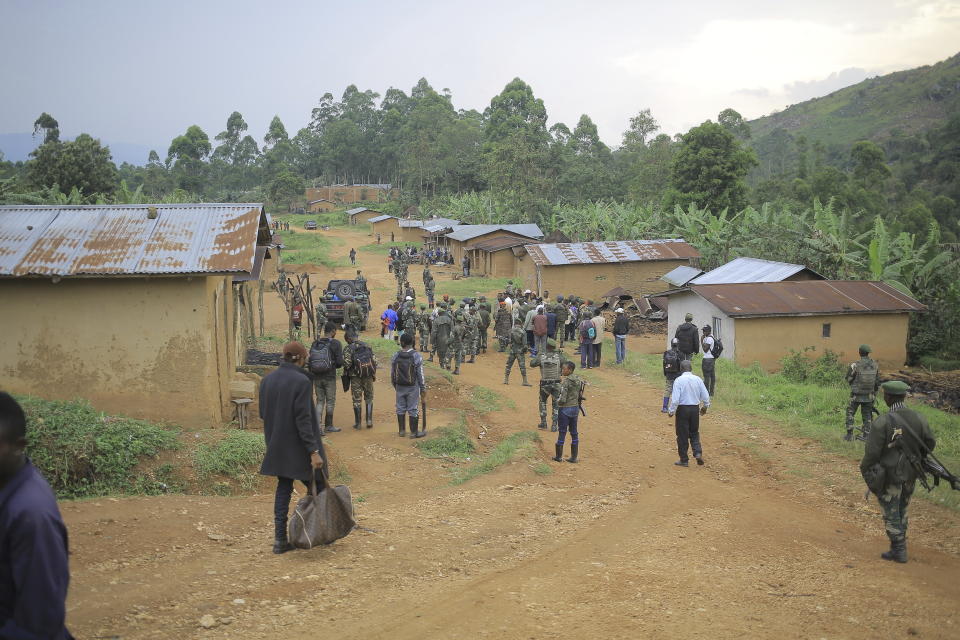 Democratic Republic of Congo Defence Forces gather in the North Kivu province village of Mukondi, Thursday March 9, 2023. At least 36 were killed when the Allied Democratic Forces, a group with links to the Islamic State group, attacked the village and burned residents' huts. (AP Photo/Socrate Mumbere)