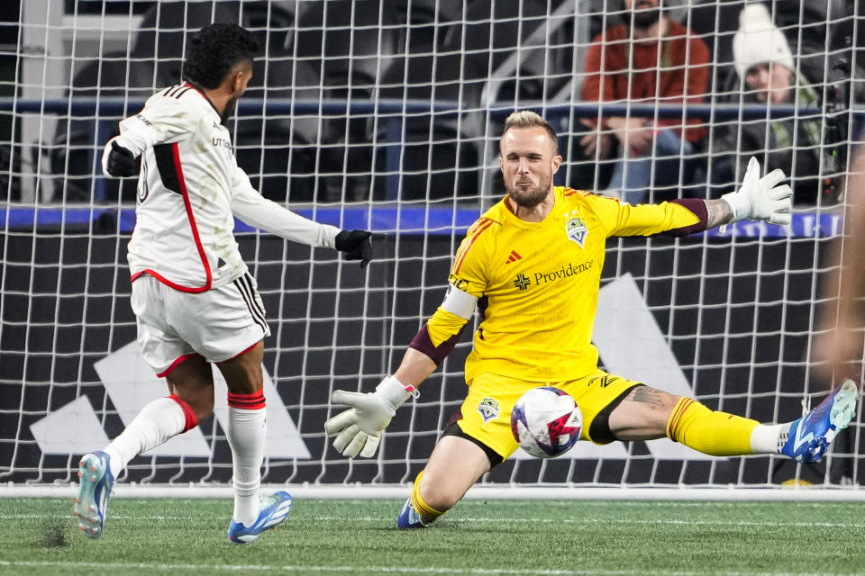 Seattle Sounders goalkeeper Stefan Frei, right, reaches to make a point-blank save against FC Dallas forward Jesús Ferreira, left, during the first half of an MLS playoff soccer match Monday, Oct. 30, 2023, in Seattle. (AP Photo/Lindsey Wasson)