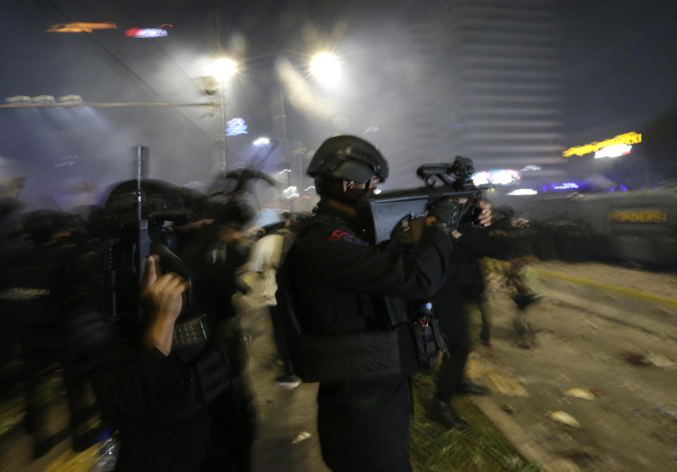 Police officers fire warning shots to disperse supporters of Indonesian presidential candidate Prabowo Subianto during a clash in Jakarta, Indonesia, Wednesday, May 22, 2019. Indonesian President Joko Widodo said authorities have the volatile situation in the country's capital under control after a number of people died Wednesday in riots by supporters of his losing rival in last month's presidential election. (AP Photo/Achmad Ibrahim)