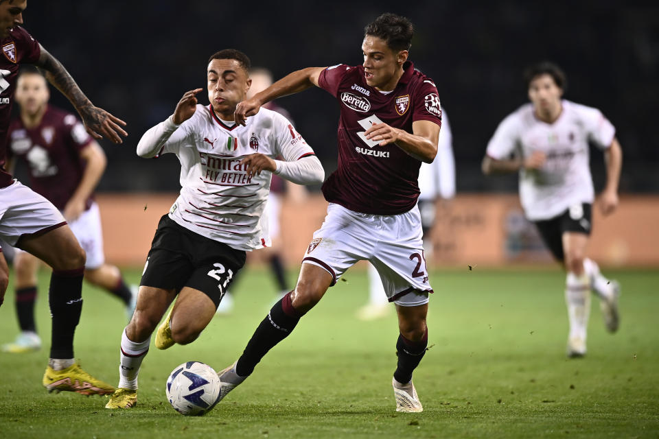 Samuele Ricci, de Torino, y Sergiño Dest, de AC Milan, compiten por el balón durante el partido de fútbol de la Serie A entre Torino y AC Milan, en el estadio Olímpico de Turín, el domingo 30 de octubre de 2022. (Fabio Ferrari/LaPresse vía AP)