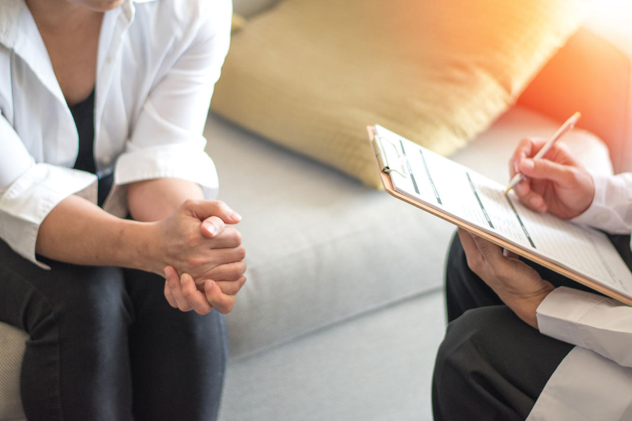 Woman consulting with psychologist Getty Images/Pornpak Khunatorn