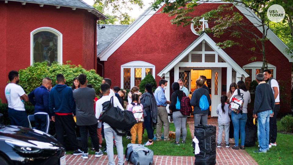 Immigrants gather with their belongings outside St. Andrews Episcopal Church, Wednesday Sept. 14, 2022, in Edgartown, Mass., on Martha's Vineyard.