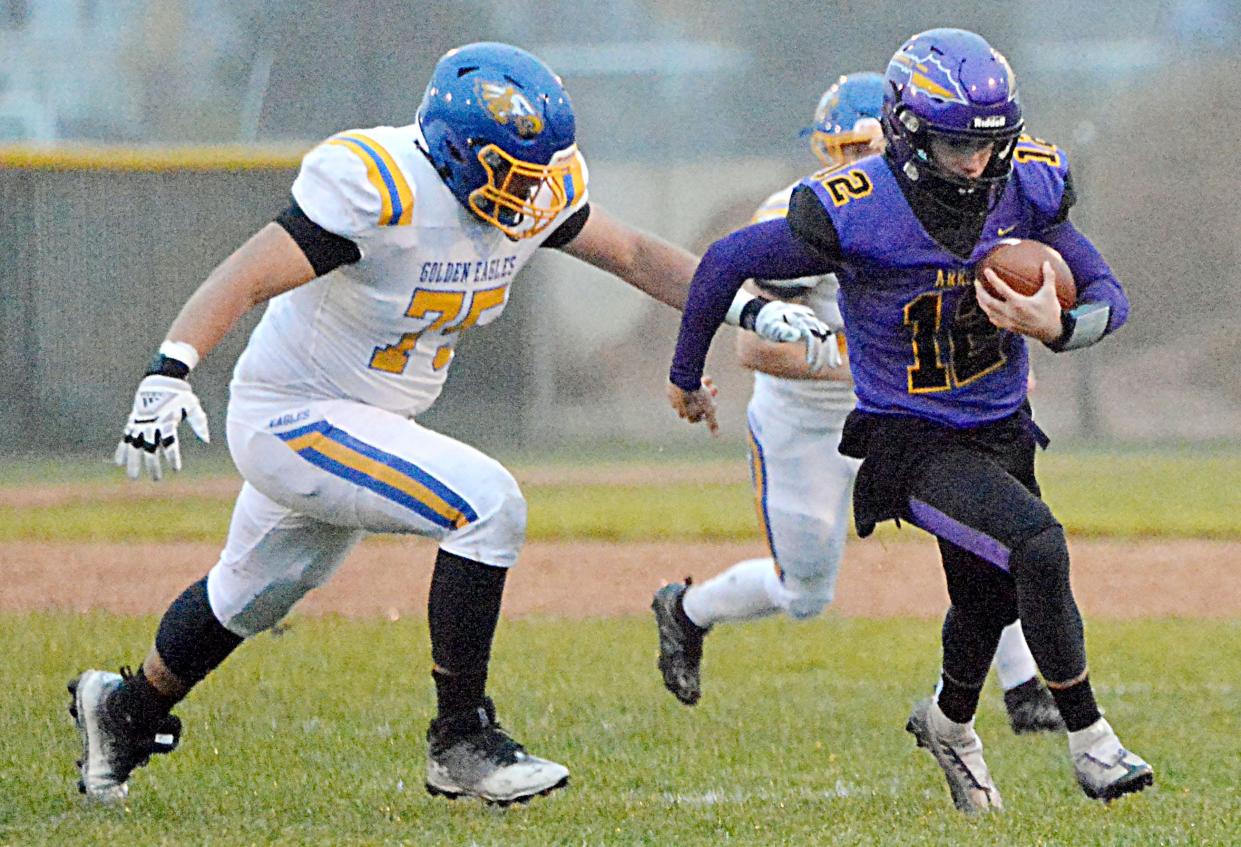 Watertown quarterback Treyton Himmerich (12) turns the corner against Aberdeen Central's Felipe Gonzalez during their first-round game in the state Class 11AA high school football playoffs on Thursday, Oct. 26, 2023 at Watertown Stadium.