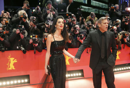 Cast member George Clooney and his wife Amal arrive on the red carpet for the screening of the movie 'Hail, Caesar!', during the opening gala of the 66th Berlinale International Film Festival, in Berlin, Germany February 11, 2016. REUTERS/Fabrizio Bensch