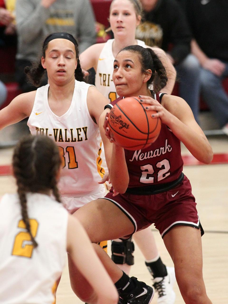 Newark's Jenna Shackleford looks to score between Tri-Valley defenders MacKenzie Harvey (31) and P.D. Moore (2) on Wednesday, Feb. 22, 2023 at Johnstown.