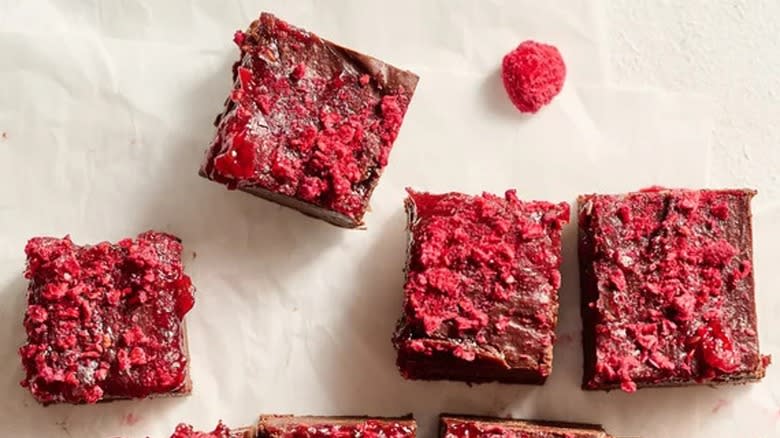 Overview of raspberry fudge pieces with fresh raspberries