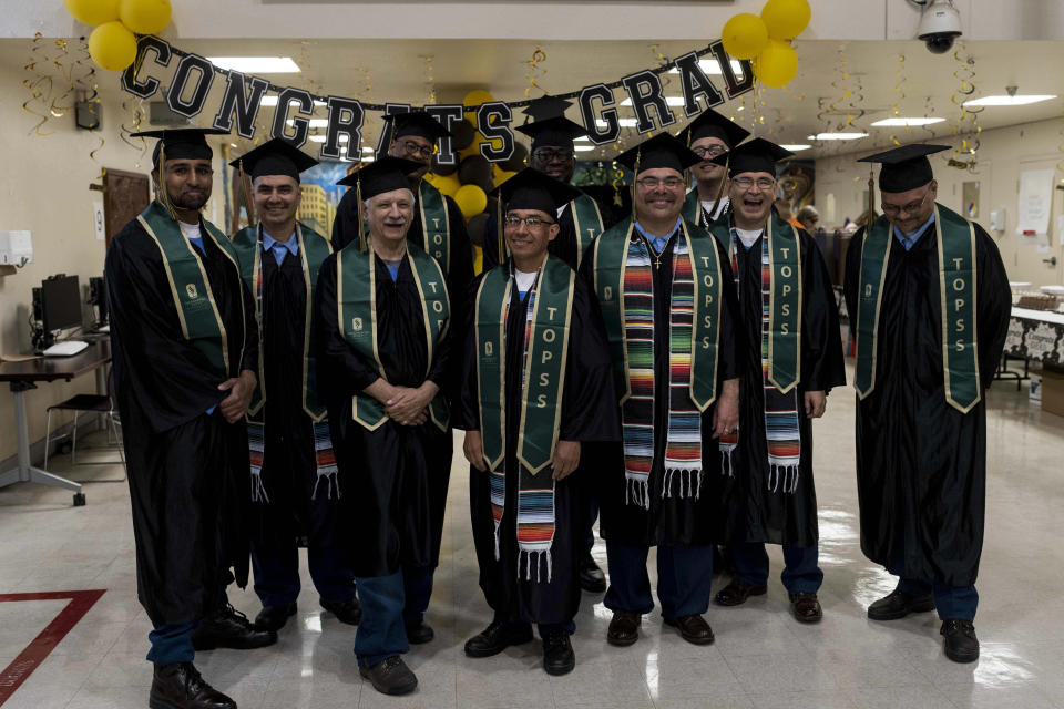 Incarcerated graduates, who finished their bachelor's degree program in communications through the Transforming Outcomes Project at Sacramento State (TOPSS), stand for a group photo in their cap and gowns before their graduation ceremony at Folsom State Prison in Folsom, Calif., Thursday, May 25, 2023. Many more prisoners will have opportunities to leave prison with bachelor's degrees when new federal rules on financial aid for higher education take effect in July. (AP Photo/Jae C. Hong)
