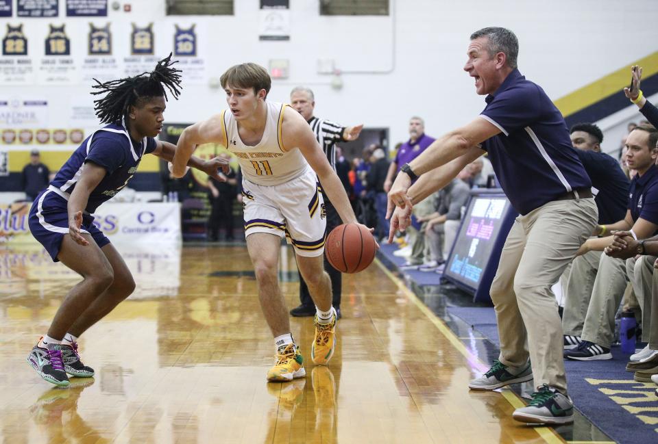 Lyon County's Travis Perry tries to drive around Great Crossing's Junius Burrell as Great Crossing head coach Steve Page shouts from the sidelines in Monday's King of the Bluegrass in Fairdale. Dec. 19, 2022 