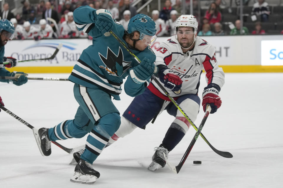 San Jose Sharks center Mikael Granlund, left, skates toward the puck next to Washington Capitals right wing Tom Wilson during the first period of an NHL hockey game in San Jose, Calif., Monday, Nov. 27, 2023. (AP Photo/Jeff Chiu)