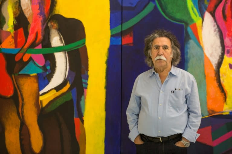 Iraqi artist Dia Al-Azzawi poses for a picture with his work at the Arab Museum of Modern Art in the Qatari capital Doha, on October 19, 2016