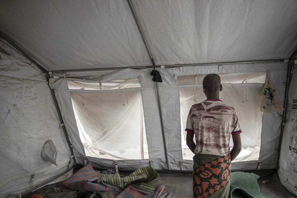 In this July 21, 2019 photo, 15-year-old Nogos stands in a tent at the "22nd May Stadium" where he took shelter with other migrants, in Aden, Yemen. He was one of at least 7,000 minors who made the journey without an adult in 2019, a huge jump from 2,000 unaccompanied minors a year earlier, according to IOM figures. Upon landing in Yemen, Nogos had been imprisoned by smugglers. For more than three weeks, they beat him, demanding his family send $500. When he called home, his father curtly refused: “I’m not the one torturing you.” Nogos can’t blame his father. “If he had money and didn’t help me, I’d be upset,” he said. “But I know he doesn’t.” (AP Photo/Nariman El-Mofty)