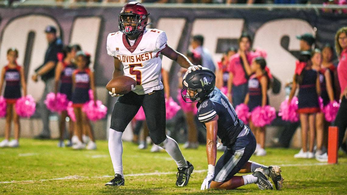 Clovis West wide receiver Marshel Sanders, left, pats Clovis East defender Fresno Moua on the head after catching a touchdown pass in the end zone during the first half of their game at Lamonica Stadium on Friday, Oct. 7, 2022.