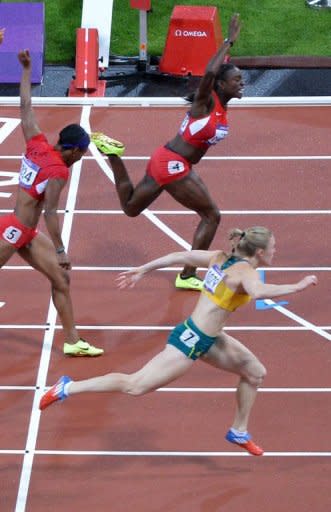 Australia's Sally Pearson (bottom), USA's Kellie Wells and USA's Dawn Harper (top) cross the finish line of the women's 100m hurdles final at the athletics event during the London 2012 Olympic Games in London