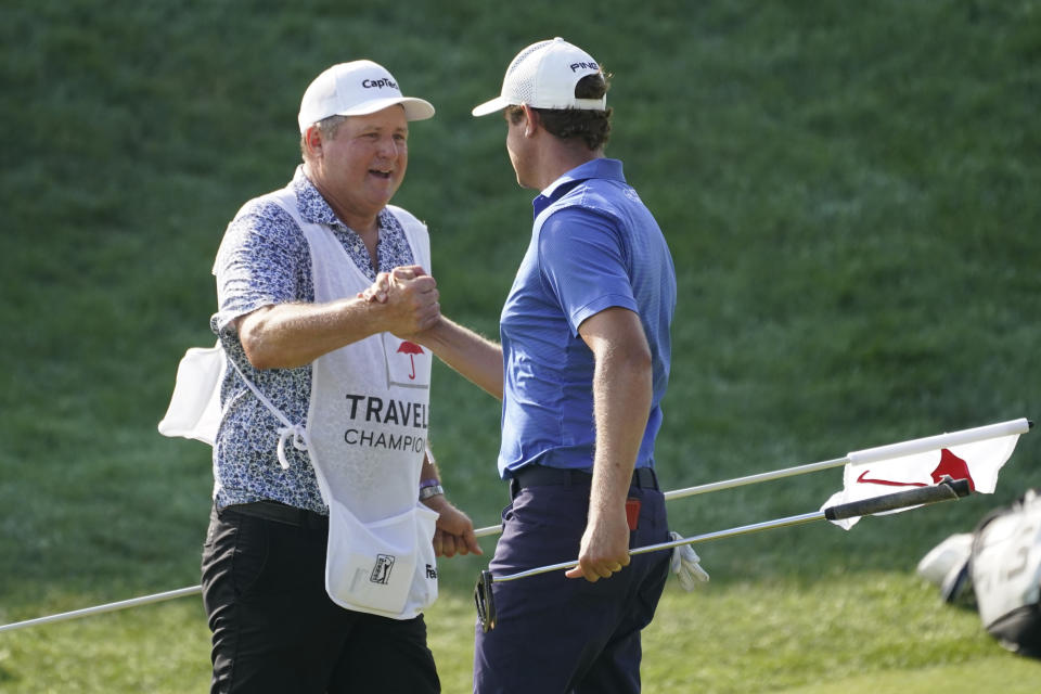 Harris English, right, celebrates a birdie on the 18th green with his caddie during the final round of the Travelers Championship golf tournament at TPC River Highlands, Sunday, June 27, 2021, in Cromwell, Conn. (AP Photo/John Minchillo)