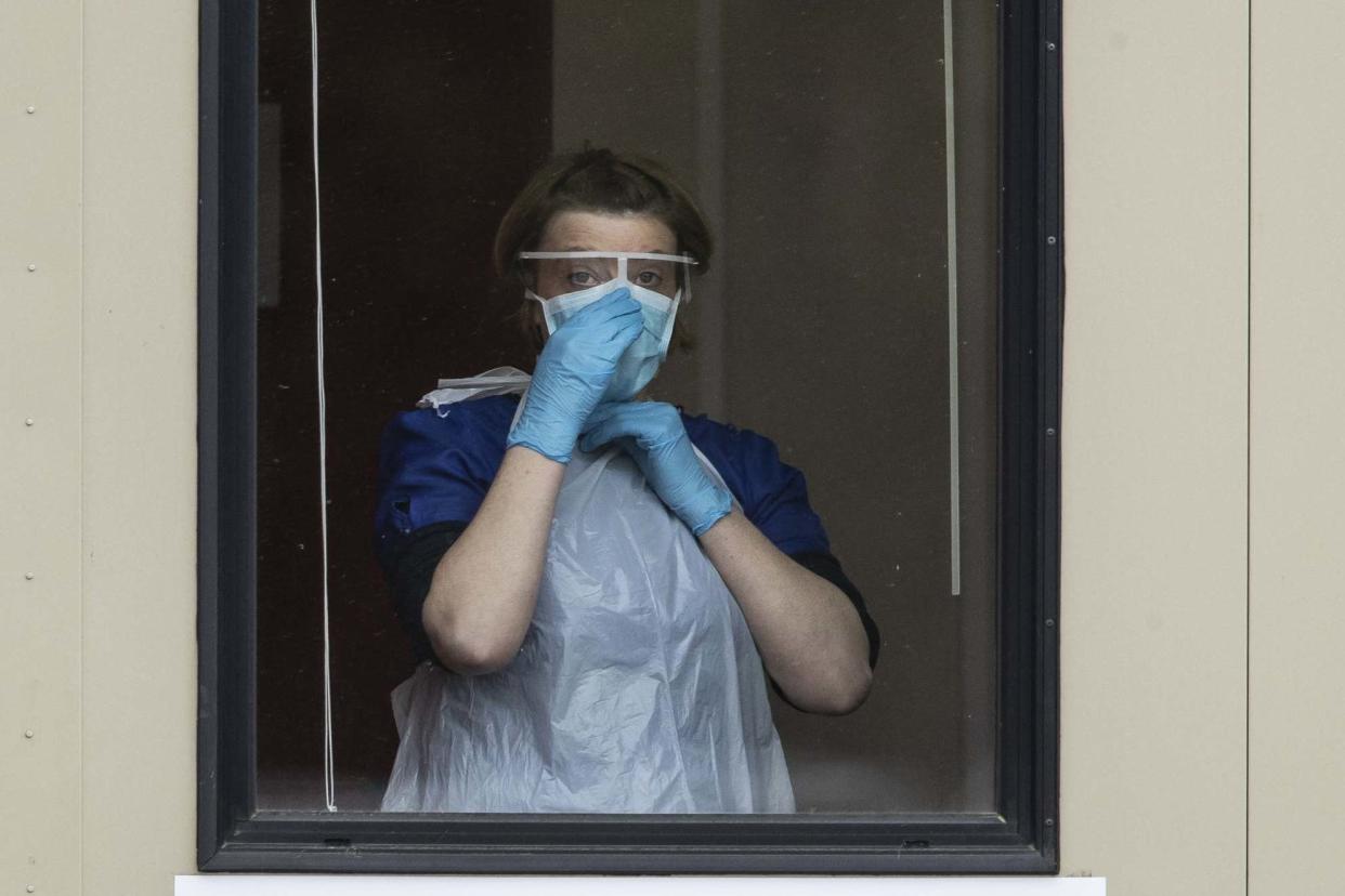 A nurse adjusts her face mask before taking swabs at a Covid-19 drive-through testing station for NHS staff: Getty Images