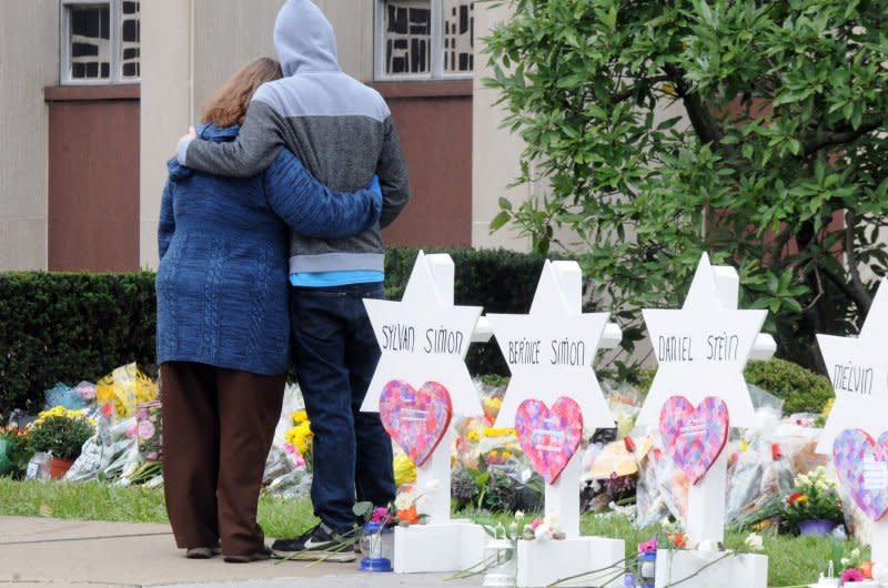 A couple embrace on Oct. 28, 2018, after placing flowers at the temporary memorial at the Tree of Life Synagogue where 11 people were killed over the weekend in the Squirrel Hill neighborhood of Pittsburgh. File Photo by Archie Carpenter/UPI