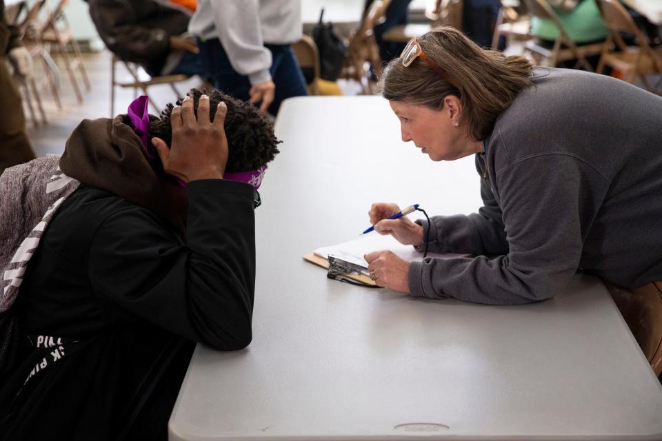 Lisa Anderson (right), executive director of Room In The Inn, speaks with an unhoused person and asks them questions to check them in for the Room In The Inn program at First Presbyterian Church in Downtown Memphis, Tenn., on Wednesday, November 1, 2023. This was the first night that Room in the Inn held a congregational shelter night in this year’s winter season, which gives Memphis’ unhoused population a way to escape the cold.